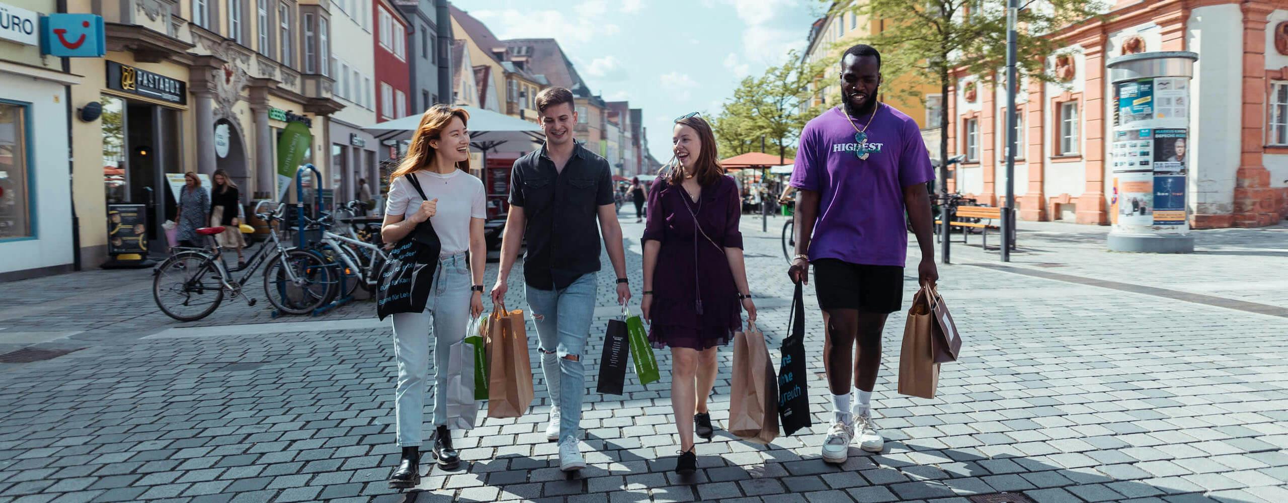 Vier glückliche Studierende beim Shoppen in der Bayreuther Innenstadt